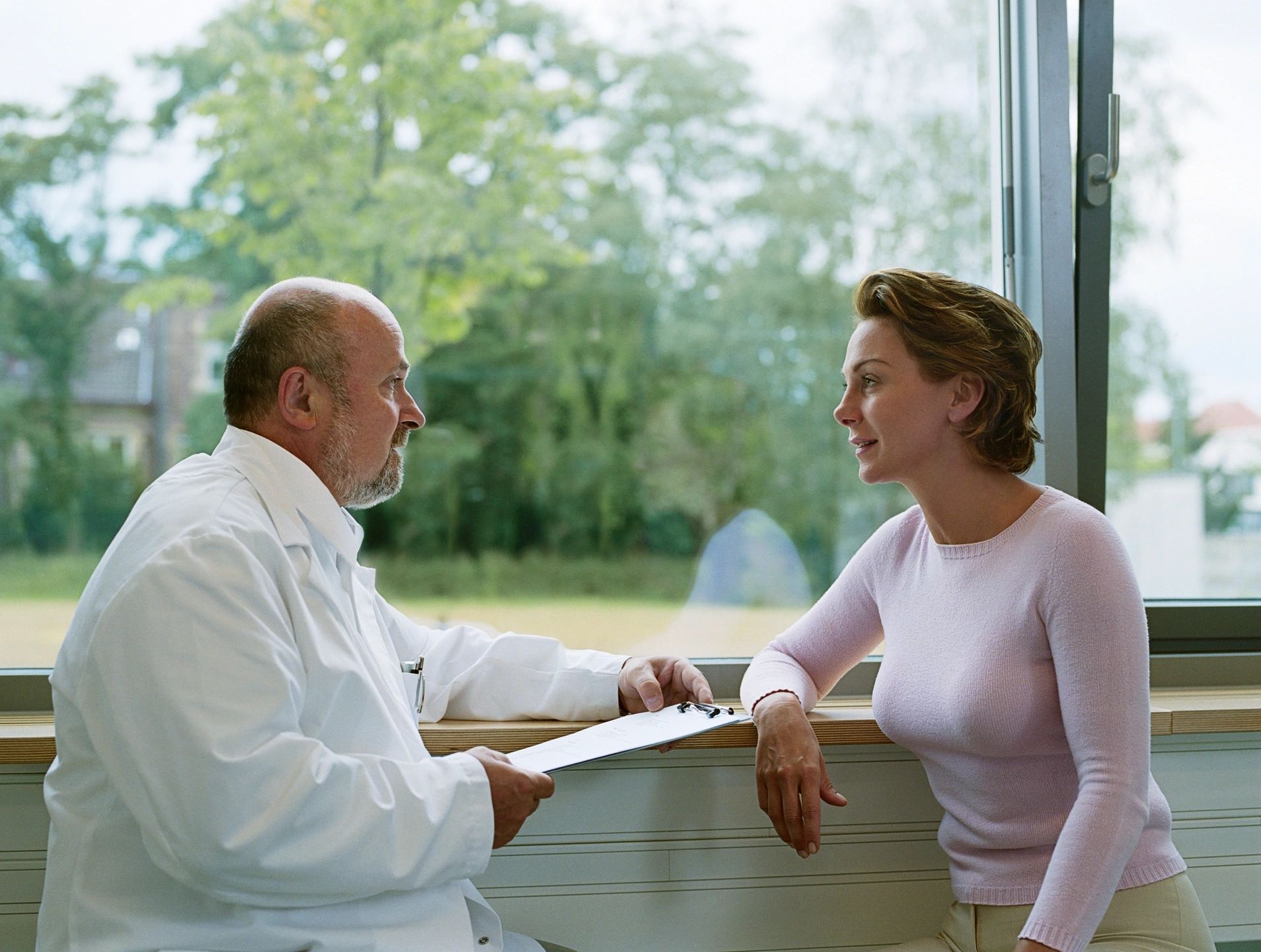 A person talking to another person wearing a white coat